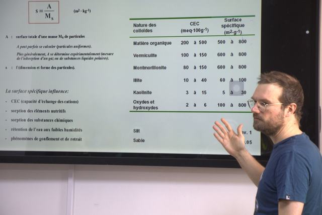 A speaker discussing a slide during a lecture