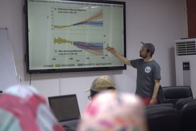 A speaker presenting graphs during a lecture